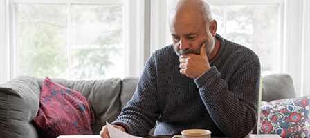 Thoughtful person with paper and coffee