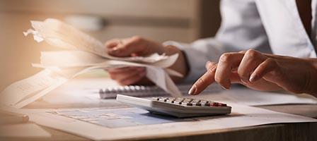 Hands calculating with documents and calculator