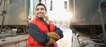 Man in red vest near trains