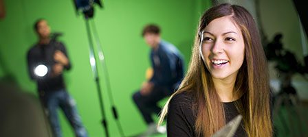 Woman smiling in a green screen studio