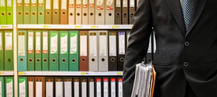Man with documents near office binders