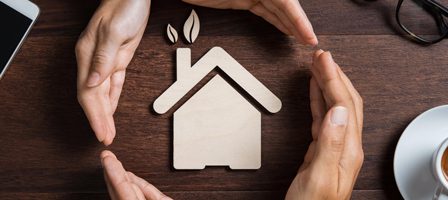 Wooden house icon with green leaves