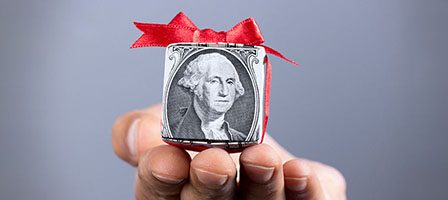 Small gift wrapped in dollar bill