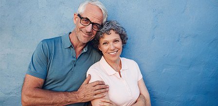 Smiling couple against blue background