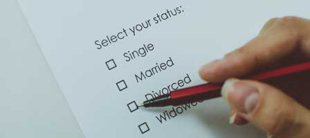 Hand holding pencil over checklist