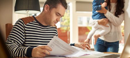 Person reading papers, child in background