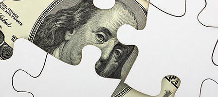 Puzzle piece revealing part of a dollar