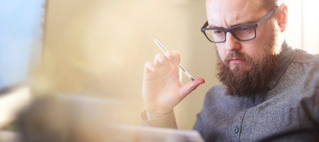 Thoughtful man holding a pen