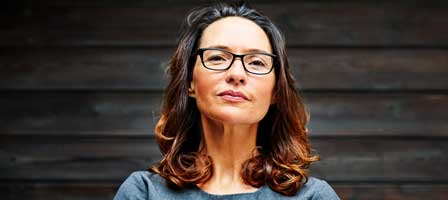 Woman standing against wooden background