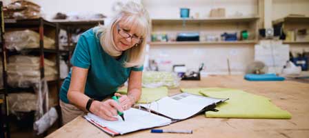 Lady taking notes in a workspace.
