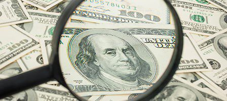 Close-up of money under magnifying glass