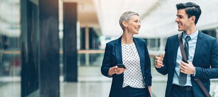 Business colleagues walking and talking in hallway