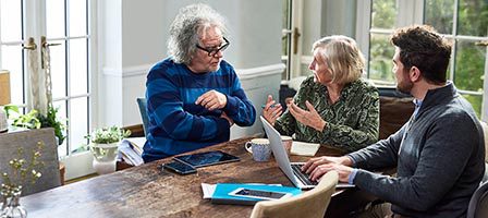 Three people having a discussion at table