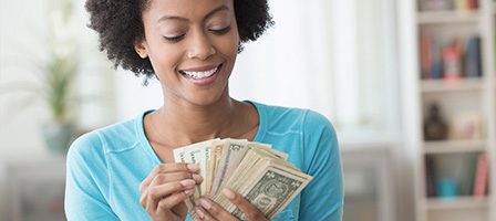 Smiling person with dollar bills