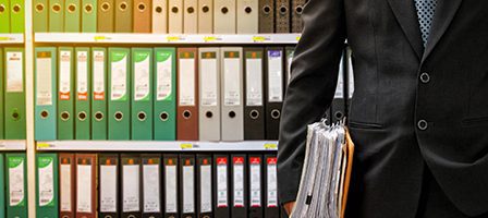 Office worker with documents in archive room