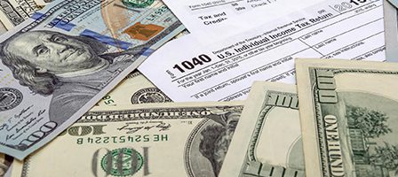 Dollar bills and tax form 1040