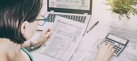 Woman calculating taxes on laptop