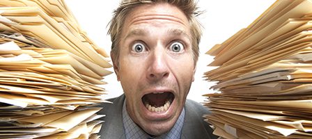 Man shocked by large pile of folders