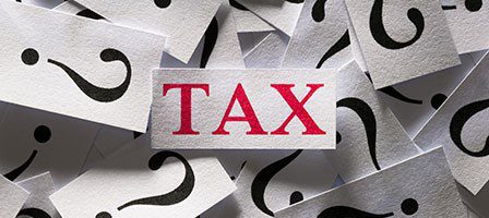 Tax surrounded by question mark cards