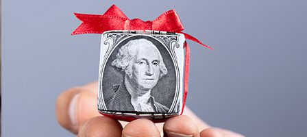 Hand holding decorated dollar-themed gift box