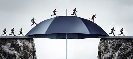 Silhouettes crossing umbrella over cliffs