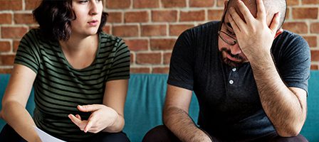 Man stressed, woman explaining something