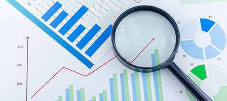 Magnifying glass over financial charts