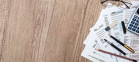 Office supplies with tax forms on table
