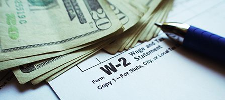 W-2 form with cash and pen