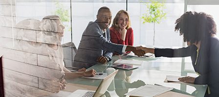 Business meeting handshake behind glass wall
