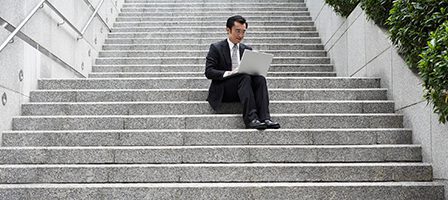Person sitting on steps with computer