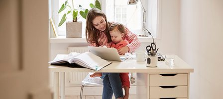 Mother multitasking with toddler on lap
