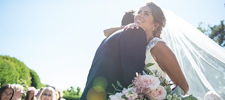 Wedding couple hugging under sunlight
