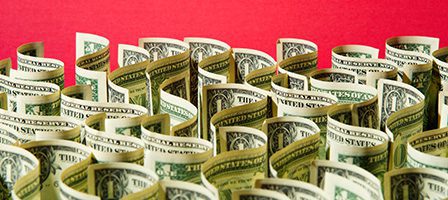 Rolled dollar bills on red background