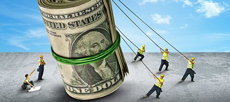Workers pulling giant roll of dollar bills