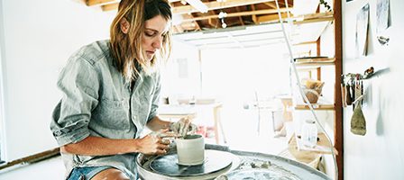 Woman crafting pottery on a wheel