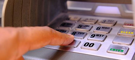 Person using ATM machine keypad