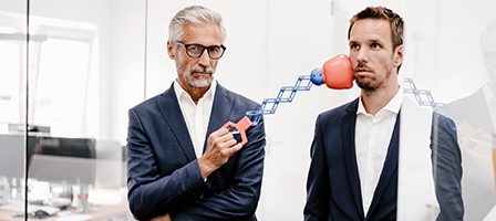 Man punching colleague with toy
