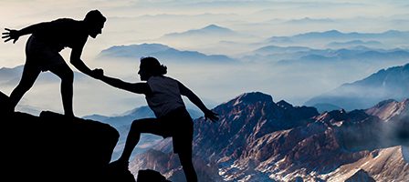 Climbers silhouetted against mountain landscape