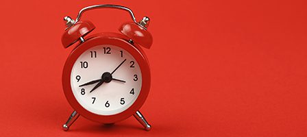 Red alarm clock on red background