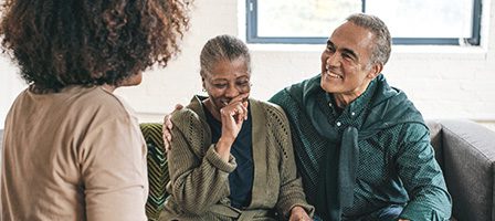 Elderly couple laughing with a friend