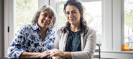 Two women sitting by a window smiling