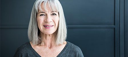 Elderly woman in gray shirt smiling