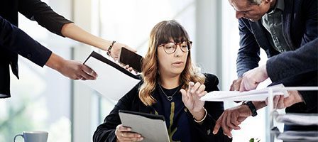 Office worker surrounded by colleagues' hands