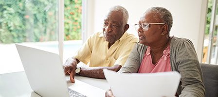 Mature adults working together on laptop