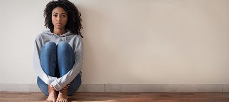 Person in gray hoodie sitting alone.
