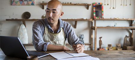 Artist focused on computer in studio