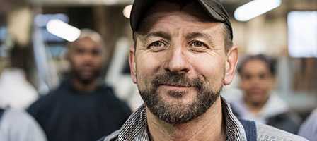 Man standing with blurred people behind
