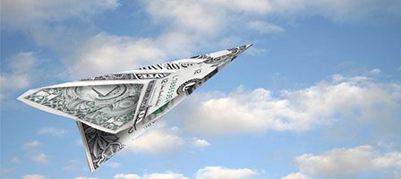 Dollar bill paper airplane in sky