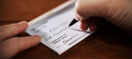 Hand writing a donation check